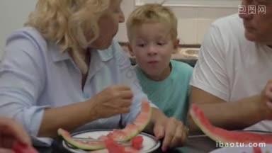 爷爷<strong>奶奶</strong>和孙子吃着成熟的西瓜，<strong>奶奶</strong>喂着顽皮的小男孩