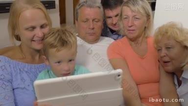 孩子的父母和祖父母看着平板电脑