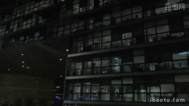 夜晚的现代玻璃办公楼或商业中心的平移镜头
