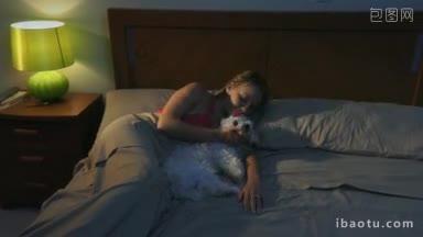 人和宠物年轻女子<strong>晚上</strong>躺在床上