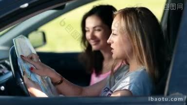 侧视图两个漂亮的女孩坐在车里，用<strong>手指</strong>在地图上铺设旅行路线