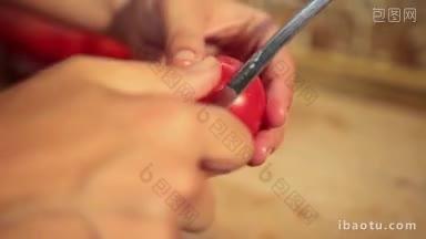 特写妇女的手在家里的厨房剥西红柿