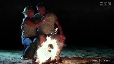 <strong>浪漫</strong>的夜晚，<strong>迷人</strong>的夫妇坐在河边的营火边，在暑假的夜晚