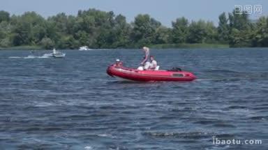 周末，在阳光明媚的日子里，快乐的一家人在河上漂浮在装有马达的红色<strong>充气</strong>船上