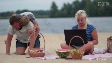 女人与笔记本电脑坐在彩色的毯子和工作在海滩上，在家庭<strong>暑假</strong>男人玩<strong>孩子</strong>