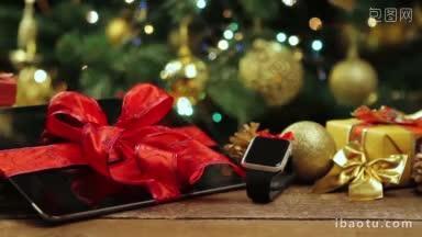 平板电脑，智能手机和智能手表与礼物和装饰品在<strong>圣诞树</strong>前与灯在木桌