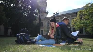 一对<strong>年轻</strong>的学生<strong>情侣</strong>背对背坐在大学校园外公园的草坪上，研究着迷人的女学生