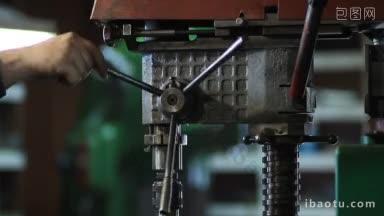 工匠在<strong>车间</strong>用钻头钻金属，工人在手动压力下使用立式钻床