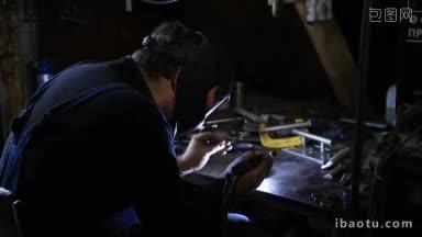 戴口罩的人在车间用tig焊机焊接钢的特写