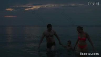 一家人在海里游泳，日落后牵着手在云朵上，在<strong>昏暗</strong>的<strong>天空</strong>背景下，母亲，父亲和儿子