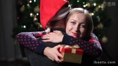年轻夫妇抱着包装<strong>好</strong>的圣诞<strong>礼</strong>物在<strong>客</strong>厅的圣诞树背景快乐感激的女人拥抱男人