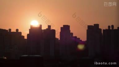 时间推移拍摄的太阳升起和移动在天空中城市现代建筑<strong>剪影</strong>的前景在红色