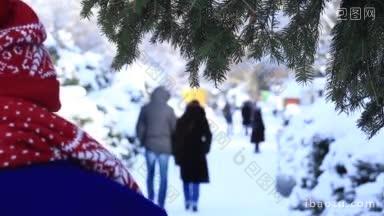后视图的妇女穿钴大衣和冬季针织配件漫步在公园在冬季后视图