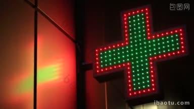靠近霓虹灯药店十字路口在晚上的角度看发光的绿色和红色的药店招牌闪烁
