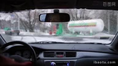 年轻的女司机开车去加油站加油，在冬天从车里看
