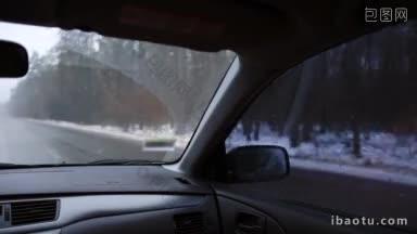 从车里看冬天风景的妇女驾驶汽车在高速公路上雪在冬天穿过森林