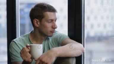 画像的年轻人坐在窗户上咖啡杯看黎明后的城市风景<strong>早起</strong>醒来