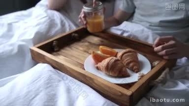 相爱的情侣在卧室里一起休闲交流，在家里的床上吃浪漫的早餐
