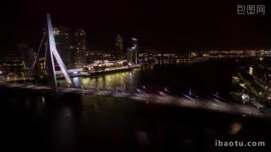 夜晚鹿特丹河上灯火通明的伊拉斯姆斯桥上的汽车交通和船只航行的延时镜头