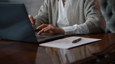 未知的成熟的女人手工作电脑首页夫人触碰触控板