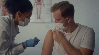 女人医生注射科维德疫苗男人。肩膀医生注射器