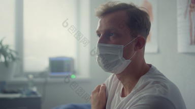 累了病人坐着穿面具诊所特写镜头男人。等待医生