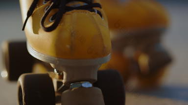 特写镜头黄色的辊溜冰鞋细节女溜冰者脚旱冰鞋