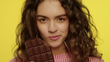 快乐女人享受巧克力酒吧慢运动模型女孩巧克力酒吧