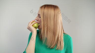 肖像金发女郎女人吃绿色苹果年轻的女人提出咬苹果