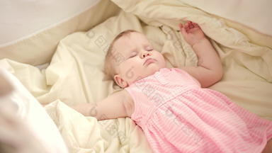 美丽的婴儿睡觉婴儿床妈妈。手抚摸睡觉孩子