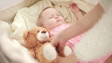<strong>妈妈</strong>。把玩具睡觉婴儿床可爱的婴儿睡眠克里