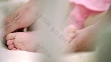 妈妈。手触碰婴儿婴儿脚家庭温柔孕妇护理