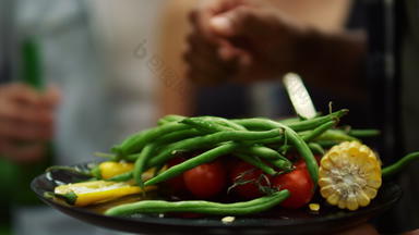 特写镜头法国豆子西红柿辣椒玉米男人。持有板