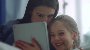 家庭享受玩平板电脑电脑特写镜头快乐的<strong>妈妈</strong>孩子有趣的