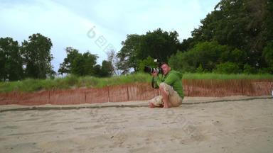 摄影师图片男人。专业相机沙子海滩
