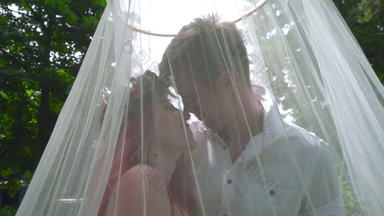 爱夫妇接吻怀孕了夫妇接吻婚礼面纱公园