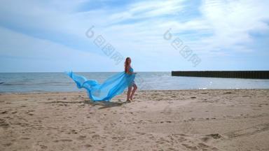 浪漫的照片会话海滩怀孕了夫妇蓝色的织物风