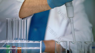 科学家手倒液体样品测试管实验室设备