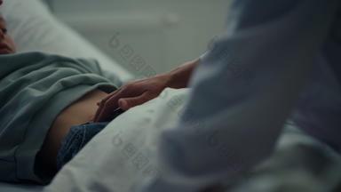 医生触碰病人胃紧急病房特写镜头生病的孩子说谎床上