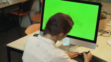 年轻的女人工作电脑绿色屏幕办公室图形设计师
