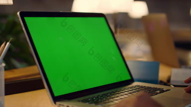 未知的手<strong>挥舞</strong>着绿色屏幕移动PC男人。视频会议在室内