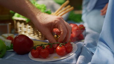 未知的人类手西红柿野餐特写镜头男人。手臂持有红色的蔬菜