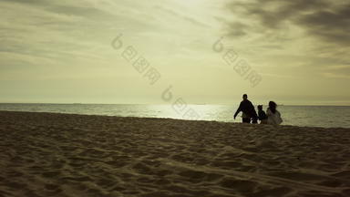 家庭走海滩早....人享受早期日出海海岸