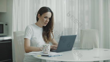 快乐女人完成工作移动PC电脑厨房微笑女人关闭移动PC