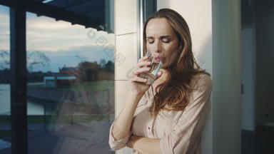 <strong>放松</strong>女人喝水全景窗口渴了夫人喝水