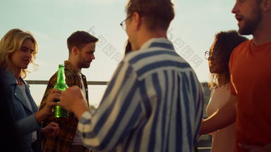 美丽的朋友聚会阳台多民族人庆祝啤酒