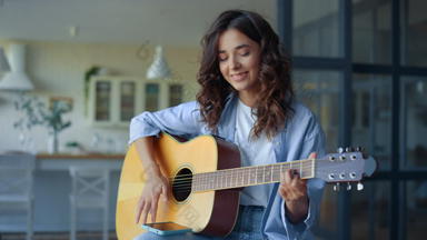 女孩玩吉他女吉他手记录吉他声音移动电话