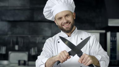 男人。老板有趣的刀厨房微笑老板锐化交叉刀