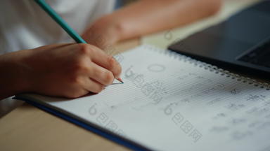 小学生手写作笔记本在室内未知的男孩家庭作业内部