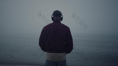 男人。听音乐耳机海海滩的家伙享受音乐耳机